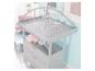 Table à langer grise avec matelas matelassé, jouets suspendus et tiroirs.