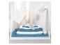Lit de jour blanc avec baldaquin, literie bleue et blanche, et traversins.