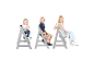 Trois enfants assis sur des chaises hautes en bois gris.