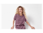 Modèle en t-shirt et pantalon mauves.
