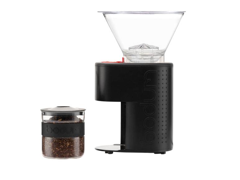 Moulin à café noir et pot en verre avec du café moulu sur fond blanc.