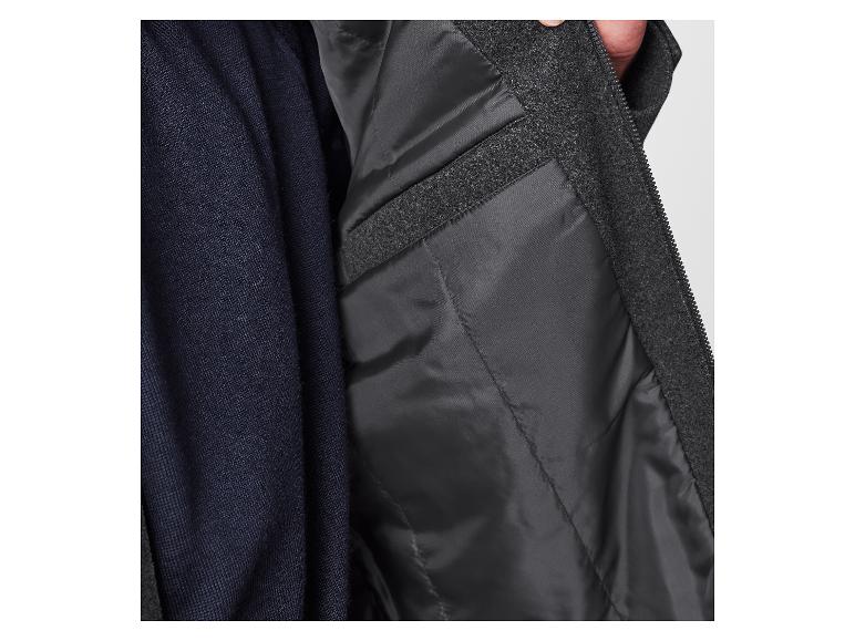 Gros plan d'un pull bleu foncé et d'une veste grise zippée.