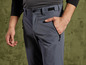Un homme porte un pantalon gris foncé avec une fermeture éclair.