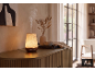 Diffuseur d'huiles essentielles lumineux sur un buffet en bois, avec un vase de fleurs séchées.