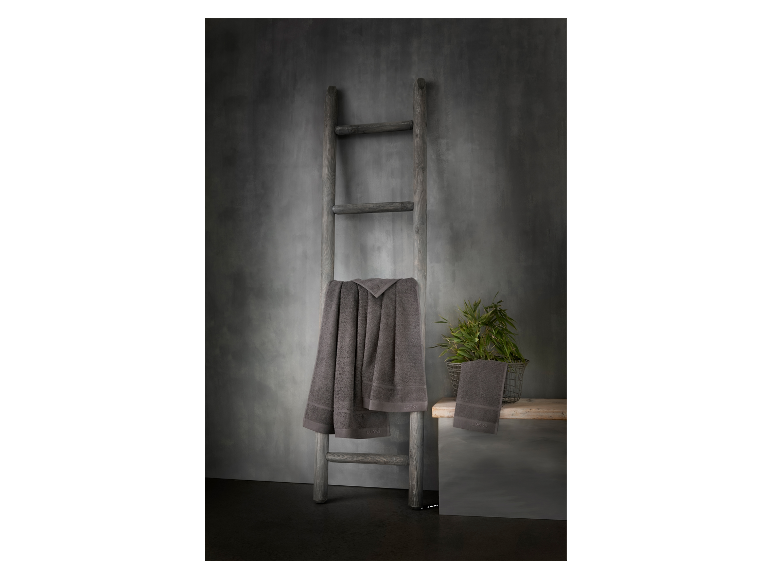 Serviettes Loeks grises sur une échelle en bois rustique.