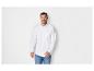 Un homme portant une chemise blanche et un jean bleu.
