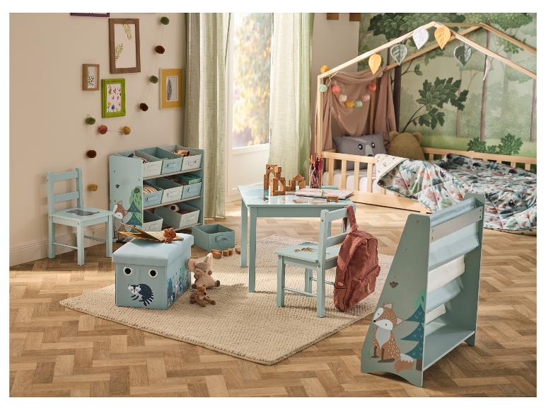 Chambre d'enfant avec un lit cabane, une table, des chaises, des étagères de rangement et un tapis sur le thème de la forêt.