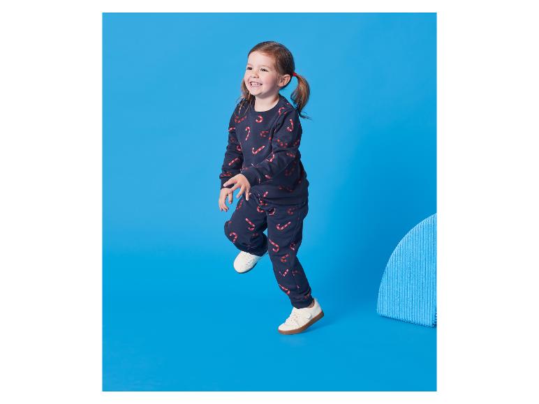 Petite fille en survêtement bleu foncé avec imprimé cannes à sucre.