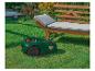 Tondeuse robot Gardena sur pelouse près d'un banc de jardin.
