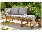 Banc de jardin en bois avec coussins gris et plaid, sur une terrasse ensoleillée.