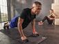 Homme faisant des pompes avec des poignées sur un tapis de fitness Craft.