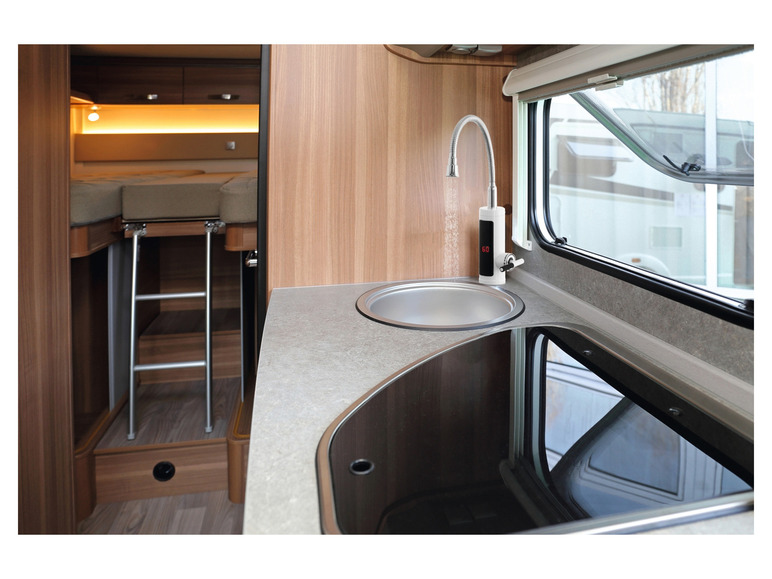 Une cuisine dans un camping-car avec un évier, une bouilloire électrique et une plaque à induction.