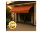 Store banne orange sur une terrasse avec l'inscription « PREMIUM QUALITÄT MADE IN GERMANY ».