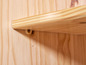 Une étagère en bois fixée à un mur en bois avec des vis.