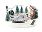 Village de Noël avec patineurs, banc, sapins et stand de Noël avec le texte 'Christmas'.