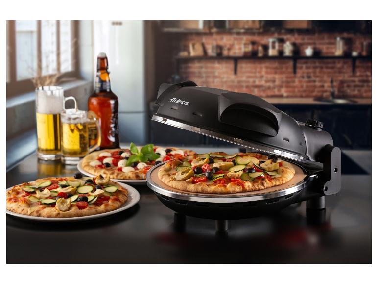 Pizza dans un four à pizza, deux pizzas sur des assiettes et de la bière sur une table.