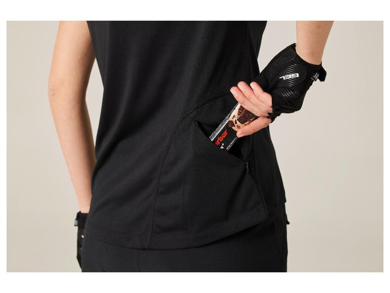 Femme en haut noir et gants, prenant une barre énergétique d'une poche latérale.