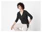 Une femme porte un pull gris foncé et un pantalon beige.