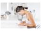 Une femme utilise un vaporisateur facial pour prendre soin de sa peau.