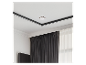 Détecteur de fumée blanc sur un plafond blanc avec bordure noire, au-dessus de rideaux sombres et d'une fenêtre.