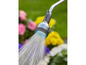 Un arroseur avec un jet d'eau large, arrosant des fleurs.