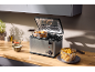 Friteuse en acier inoxydable avec nuggets de poulet et frites dans une cuisine.