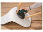 Une personne utilise un tournevis sans fil Parkside pour assembler une chaise.