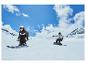 Deux personnes skient et font du snowboard sur une pente enneigée.