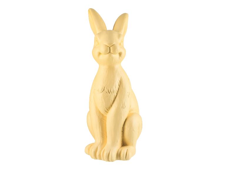 Une figurine de lapin jaune assise.