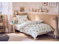 Chambre d'enfant chaleureuse avec un lit paré d'une parure de lit dinosaure et une déco ludique.