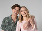 Un homme et une femme en tenue verte et rose, souriant à la caméra.