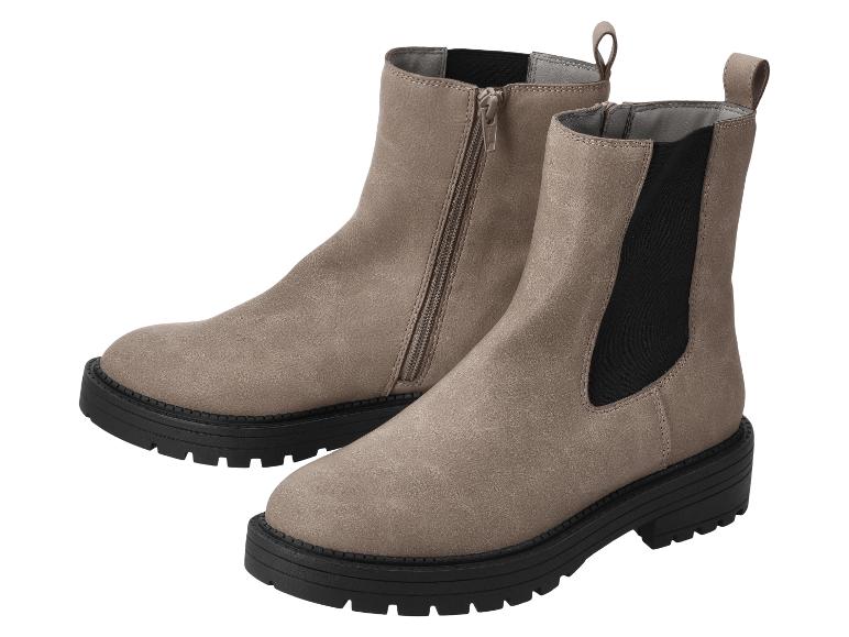 Paire de bottines marron clair à semelles noires, l'une avec fermeture éclair, l'autre avec élastique.