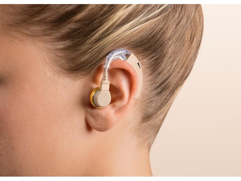 Gros plan de l'oreille d'un enfant avec un appareil auditif beige.