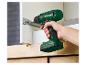 Main tenant une perceuse-visseuse sans fil Parkside, vissant une vis dans une armoire.