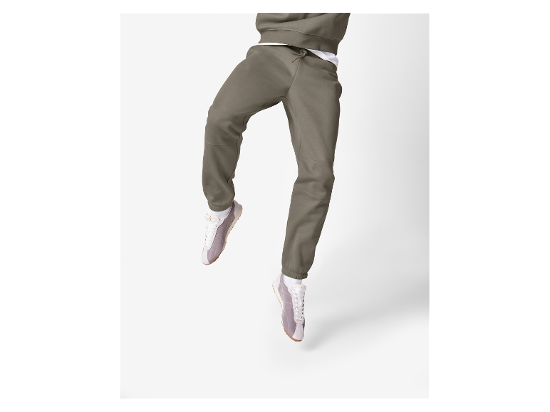 Pantalon de jogging kaki et baskets blanches.