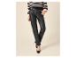 Femme en pantalon en similicuir noir, pull rayé et talons noirs.