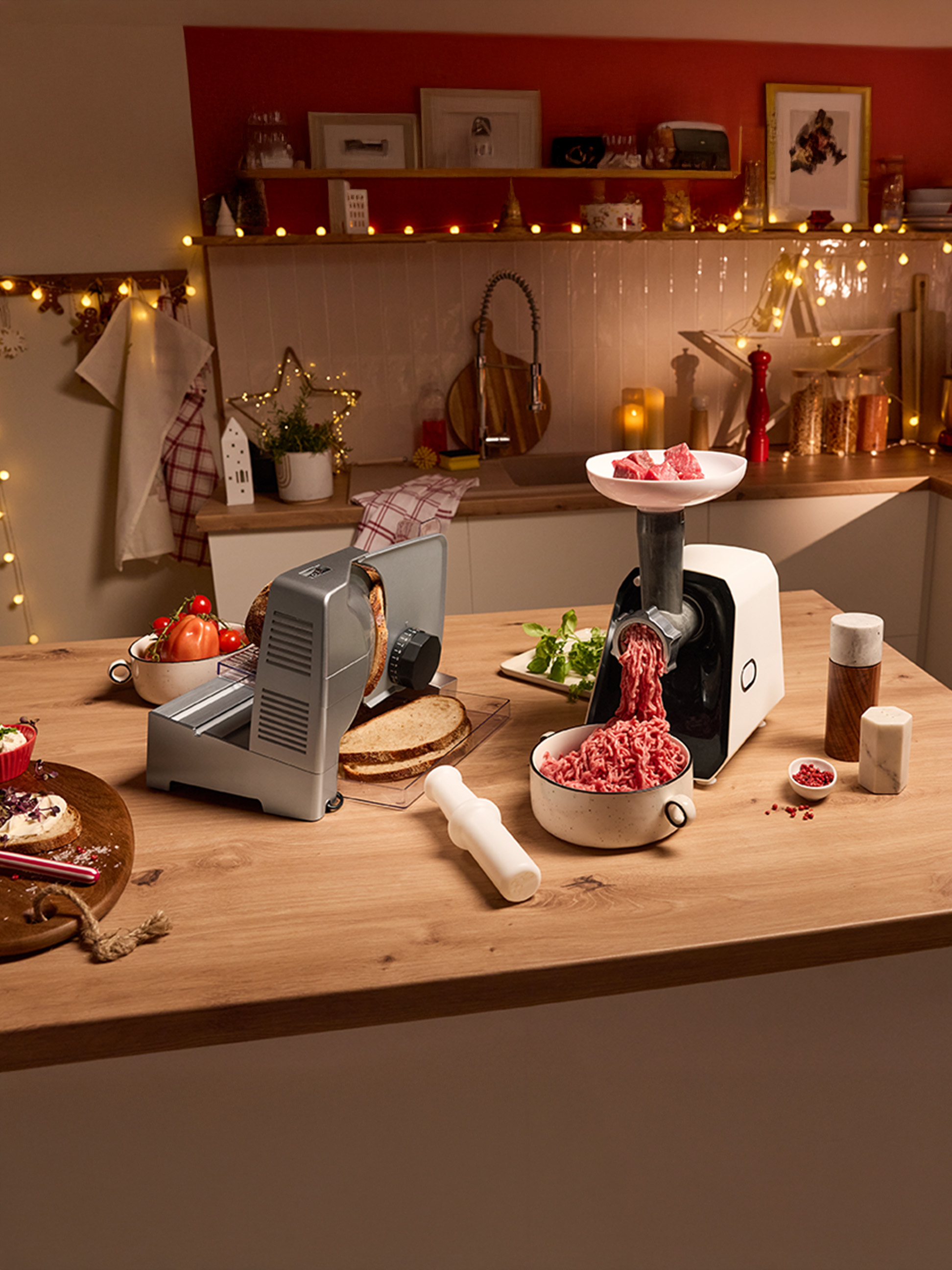 Hachoir à viande et trancheuse à pain sur un comptoir de cuisine décoré de façon festive.
