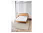 Un matelas blanc sur un sommier en bois dans une chambre à coucher.
