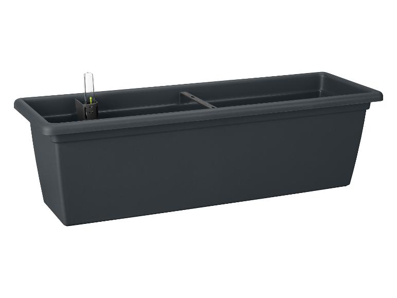 Un long pot de fleurs noir avec un système d'arrosage.