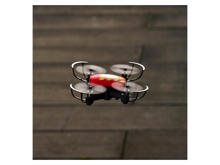 Un drone rouge et jaune avec quatre hélices en vol.