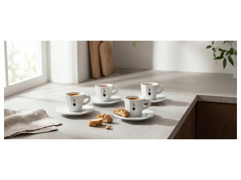 Quatre tasses à expresso avec des biscuits sur un comptoir de cuisine clair.