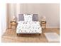 Un lit avec une couette blanche à motif floral.