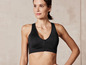Une femme porte un soutien-gorge de sport noir avec une fermeture éclair.