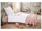 Chambre d'enfant avec lit simple et parure de lit blanche à cœurs roses.