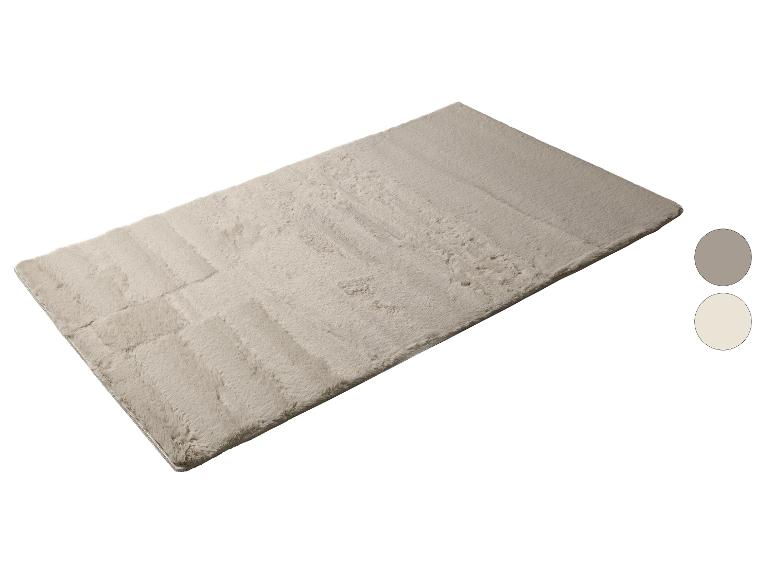 Un tapis doux et rectangulaire de couleur beige clair avec deux échantillons de couleur à côté.