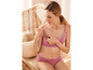 Une femme porte un soutien-gorge et une culotte roses avec dentelle.