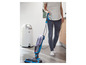 Une femme utilise un nettoyeur vapeur Bissell Spinwave pour nettoyer le sol.