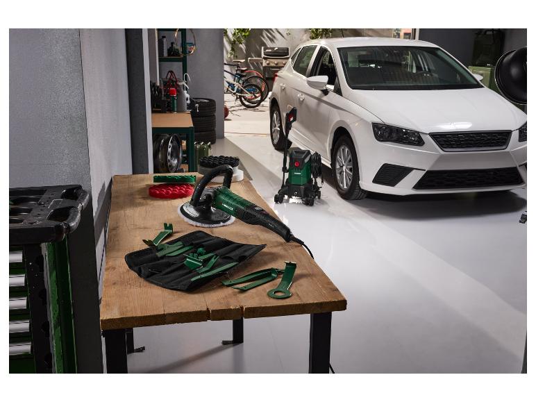 Polisseuse de voiture et nettoyeur haute pression dans un garage avec une voiture blanche.