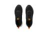 Une paire de chaussures de sport noires avec des détails orange et des semelles blanches, vue de dessus.