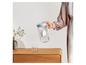 Une main tenant une carafe filtrante Brita avec un verre dessous.